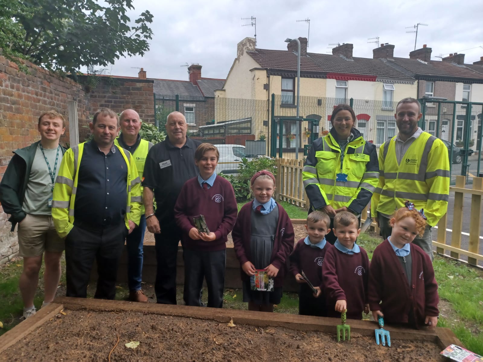 St Charles’ pupils and teachers with United Utilities, Morrison Water Services, B&Q and Travis Perkins, at the new school garden
