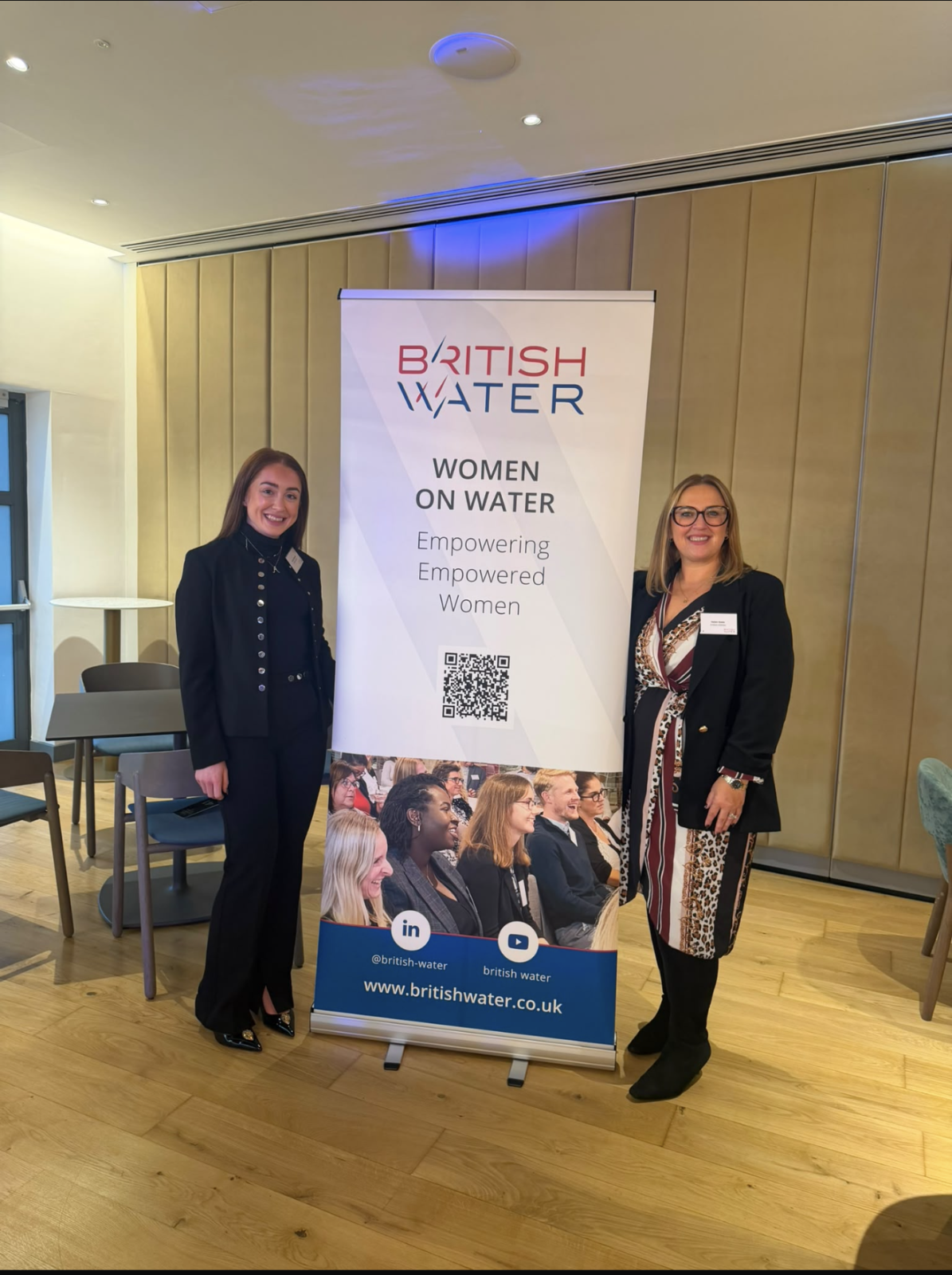 Two United Utilities attendees posed next to banner reading: WOMEN ON WATER. Empowering, Empowered, Women